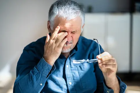 photo of man rubbing eye